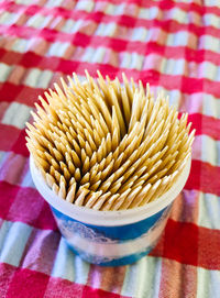 High angle view of toothpicks in container on table