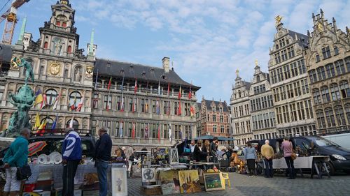 People in city against cloudy sky