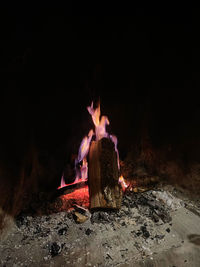Rear view of man sitting on rock at night
