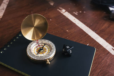 High angle view of navigational compass on book