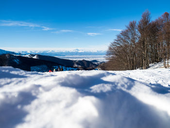 Scenic view of snow mountains against blue sky