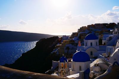 Buildings by sea against sky in town