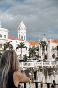 Rear view of woman looking at historic building against sky