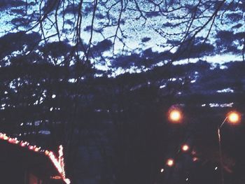 Low angle view of illuminated christmas tree against sky at night