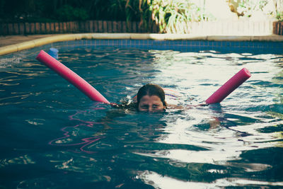 Girl with inflatable swimming in pool