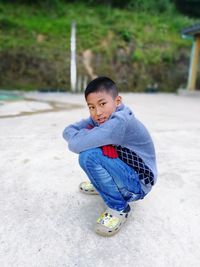 Boy crouching at beach