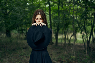 Side view of woman standing in forest