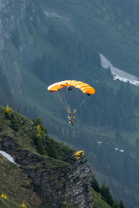 Person paragliding over mountain