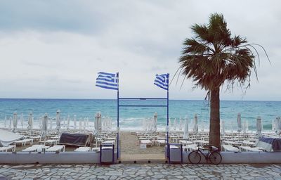 Deck chairs on beach against sky
