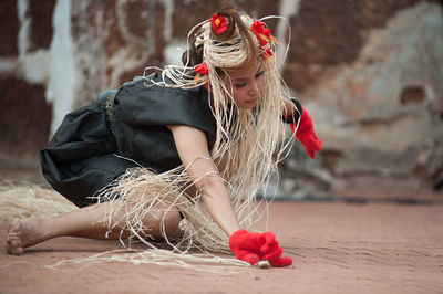 Woman with plants dancing on footpath