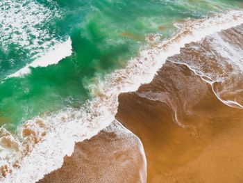 High angle view of waves splashing on shore