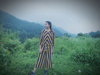 Woman standing on field against mountains