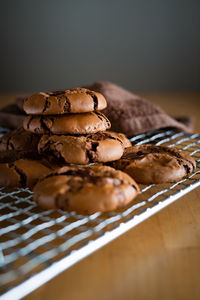 Soft dark chocolate brownie cookies on a metal rack on a wooden background.