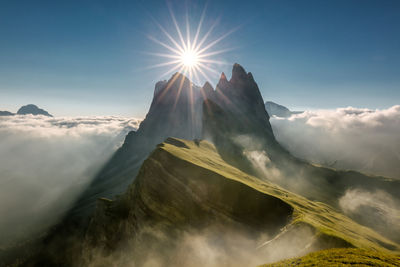 Scenic view of mountains against sky in sunny day