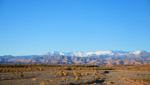 Scenic view of landscape and mountains against clear blue sky