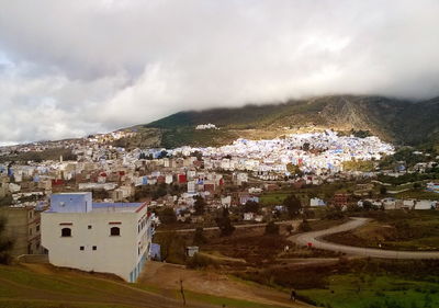 View of cityscape against cloudy sky