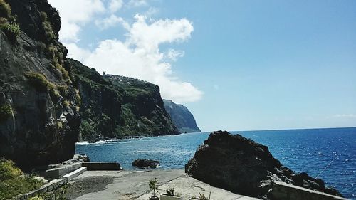 Rock formations by sea against sky