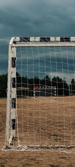 View of soccer field by sea against sky