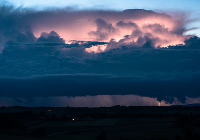 Scenic view of dramatic sky over silhouette landscape