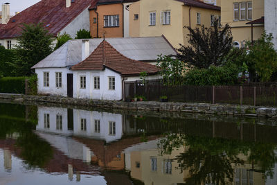 Houses by lake and buildings in city