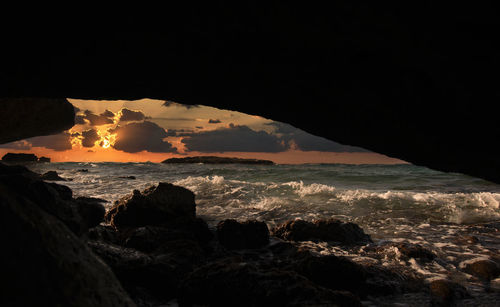 Scenic view from the cave of sea against sky during sunset