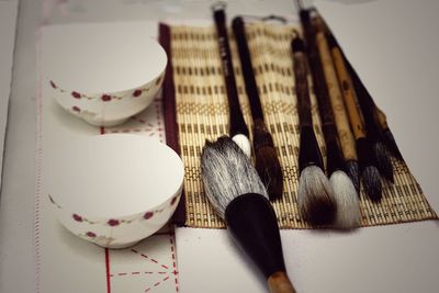 High angle view of bowls and brushes on table