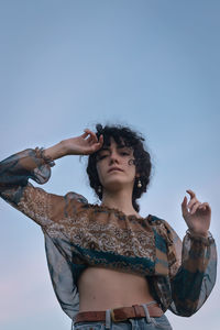 Low angle view of woman standing against sky