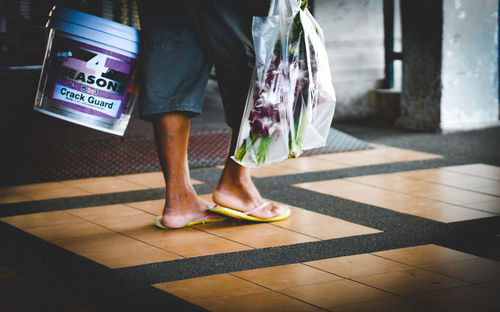 Low section of woman standing on tiled floor