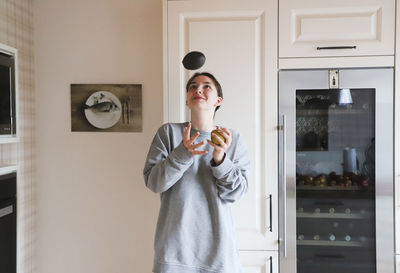 Mid adult woman standing in kitchen at home