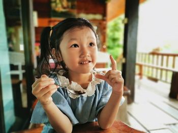 Portrait of cute baby girl holding indoors