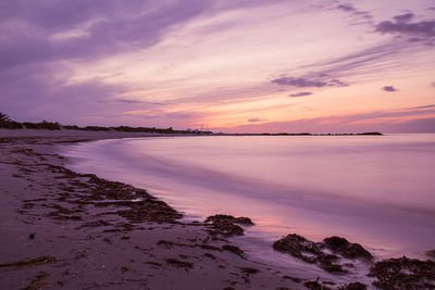 Scenic view of sea against romantic sky at sunset