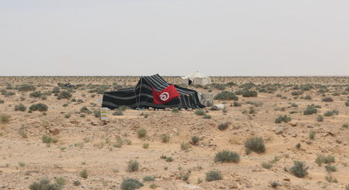 Flag on desert against clear sky