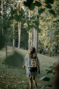 Rear view of woman walking in forest