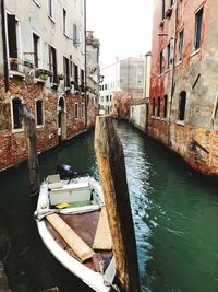 Canal amidst buildings in city against sky