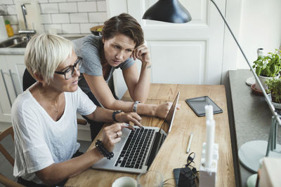 High angle view of product designers discussing over laptop at home