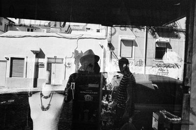 Reflection of people photographing on glass