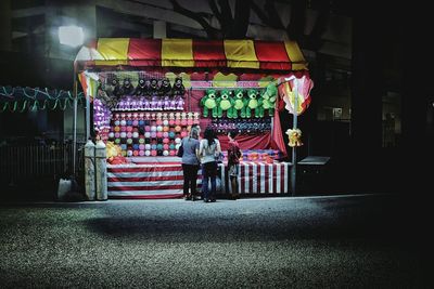 People in illuminated traditional clothing at night