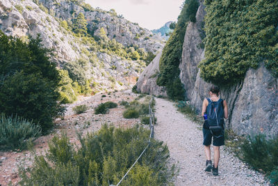 Woman hiking on a mountain path in catalonia on a cloudy summer day