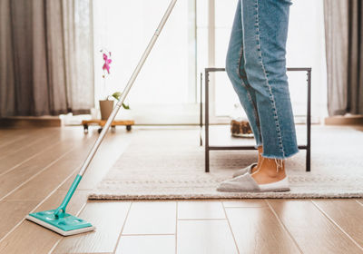 Low section of woman standing on floor at home