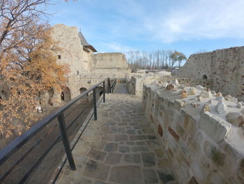 Footpath amidst buildings against sky