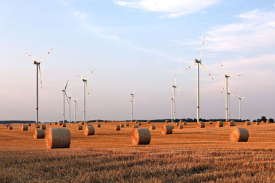 Hay bales on field against sky