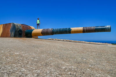 Full length of man standing on cannon against sky