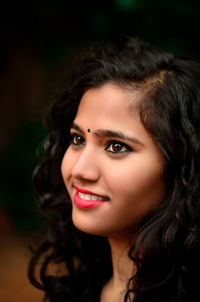 Close-up of smiling young woman looking away
