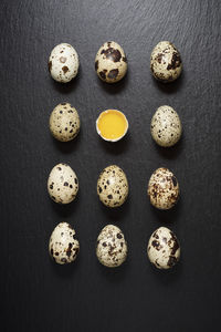 Quail eggs on a black table.