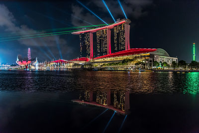 Illuminated bridge over river at night