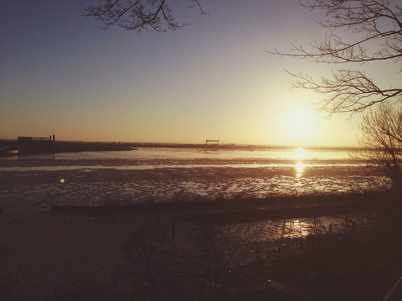 water, sunset, tranquil scene, tranquility, scenics, sun, beauty in nature, sea, nature, reflection, horizon over water, sky, lake, idyllic, silhouette, clear sky, tree, sunlight, outdoors, no people