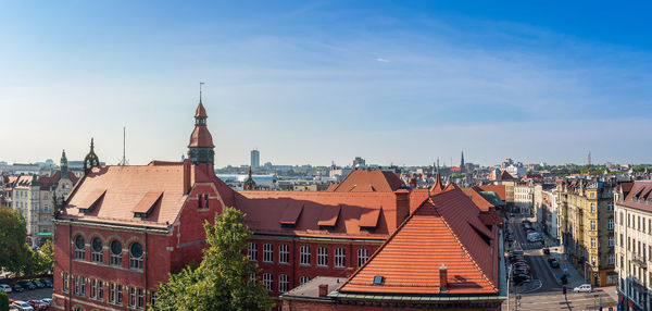 Panorama of the city of katowice. in the foreground there is a historic school building 