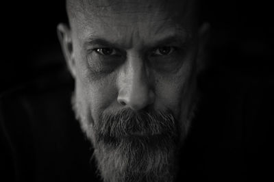 Close-up portrait of man against black background