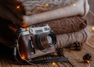 Vintage film camera and knitted items on wooden background