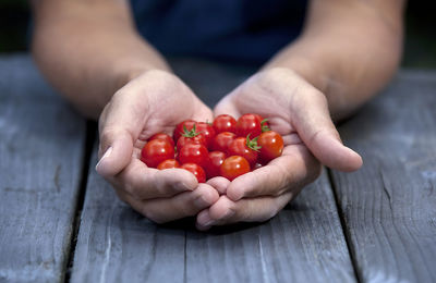 Midsection of man holding strawberries on table